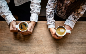 Two friends talking quietly over coffee, a gentle question shared between them, like the one between God and Elijah in a cave.